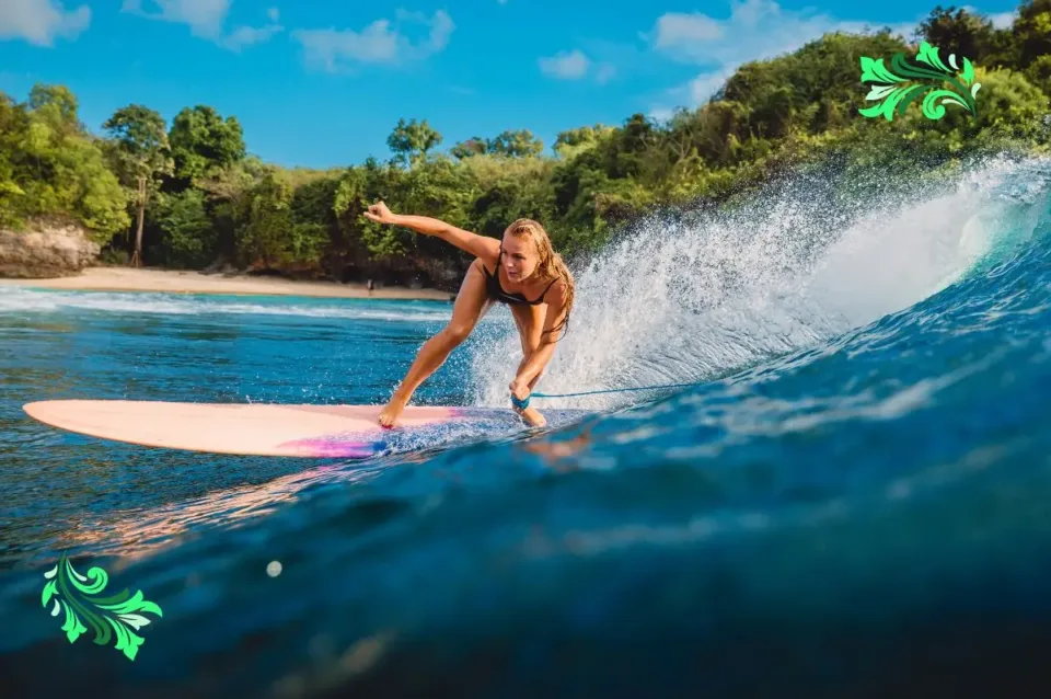 Beautiful surfer girl on surfboard. Woman in ocean during surfing in Bali