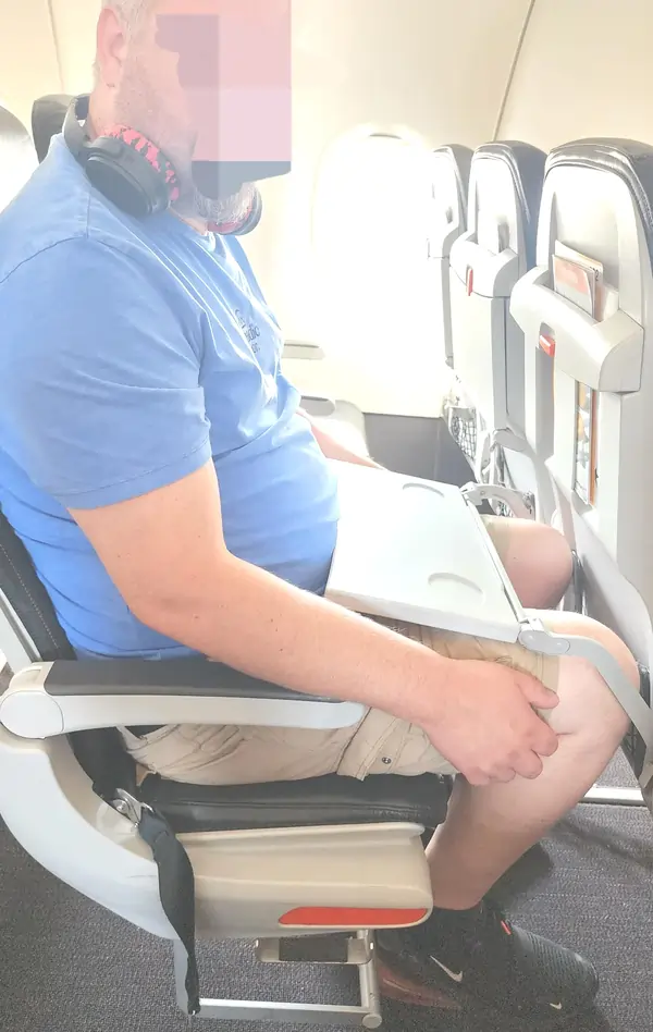 person in a skinny flight seat